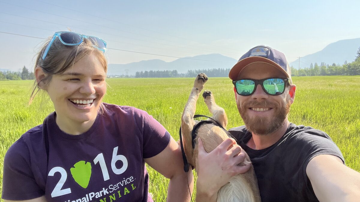 Mark, Beck, and Sinopah in a Montana field with mountains